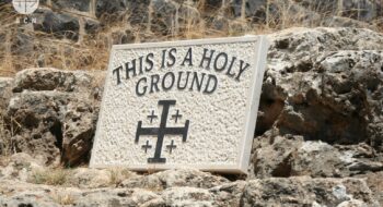 Tabuľka s nápisom "Toto je sväté územie" a s jeruzalemským krížom umiestnená na skalách